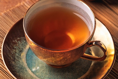 Tea cup with dry tea leaves on the side